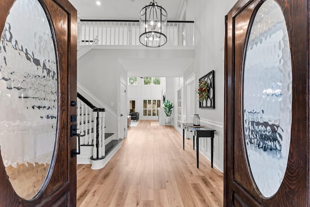 8911 Tranquil Park Dr, Spring, TX 77379 - entrance foyer with stairway, light wood-type flooring, a chandelier, and a high ceiling