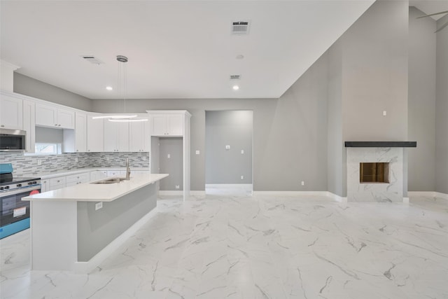 kitchen featuring white cabinetry, sink, a fireplace, and appliances with stainless steel finishes