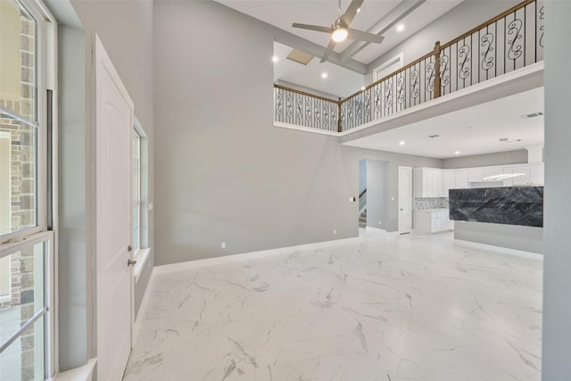 living room featuring ceiling fan and a towering ceiling