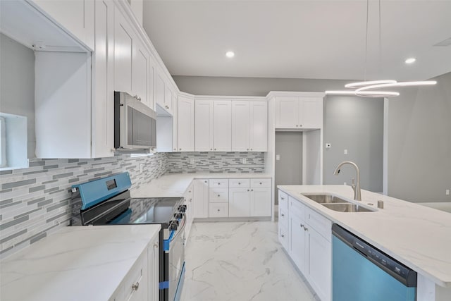 kitchen featuring sink, decorative light fixtures, white cabinets, and appliances with stainless steel finishes