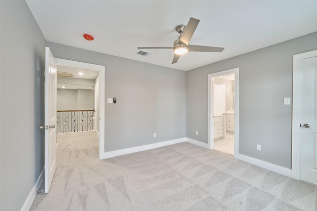 unfurnished bedroom featuring ceiling fan, light colored carpet, and connected bathroom