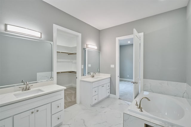 110 Broken Wheel Cir, Conroe, TX 77316 - full bathroom with two vanities, a walk in closet, a garden tub, marble finish flooring, and baseboards