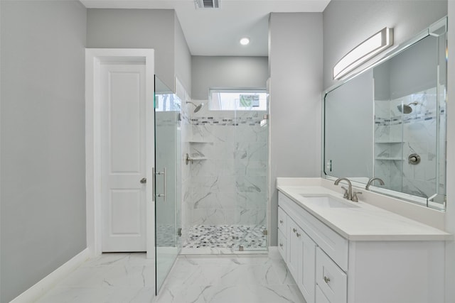 bathroom featuring a shower with door and vanity