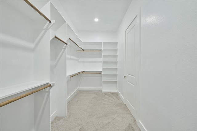 walk in closet featuring light colored carpet