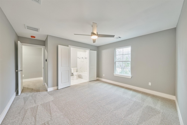 unfurnished bedroom featuring connected bathroom, light colored carpet, and ceiling fan