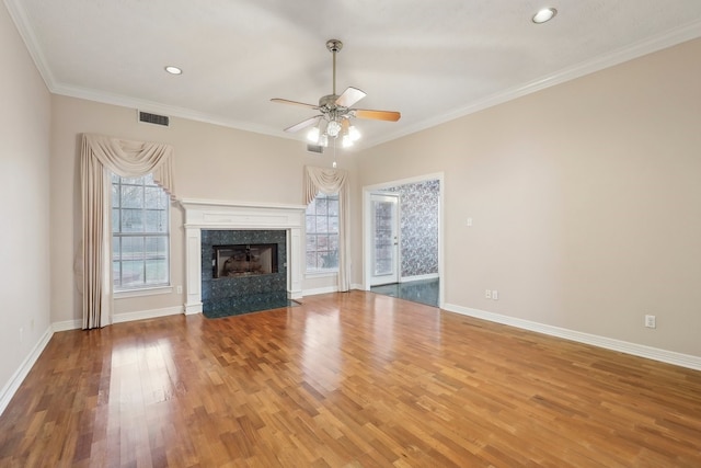 unfurnished living room featuring a fireplace, ornamental molding, hardwood / wood-style flooring, and ceiling fan