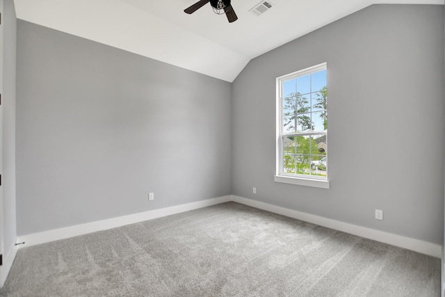 empty room featuring vaulted ceiling, ceiling fan, and carpet flooring