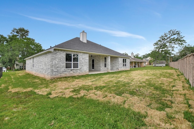 back of property featuring a patio and a lawn