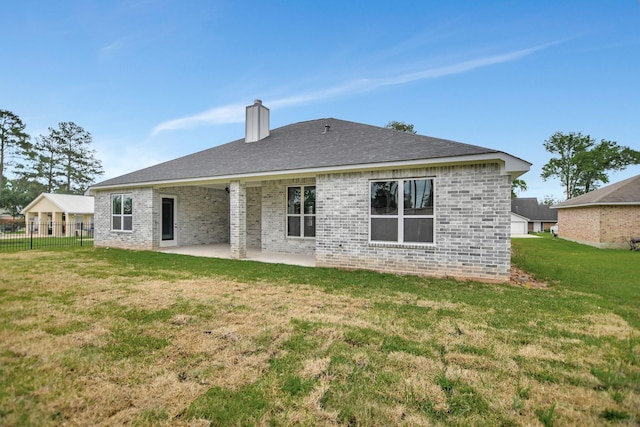 back of property with a yard and a patio