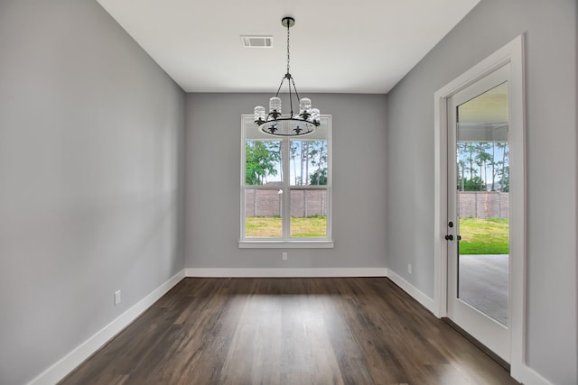 unfurnished dining area with dark wood-type flooring and a chandelier