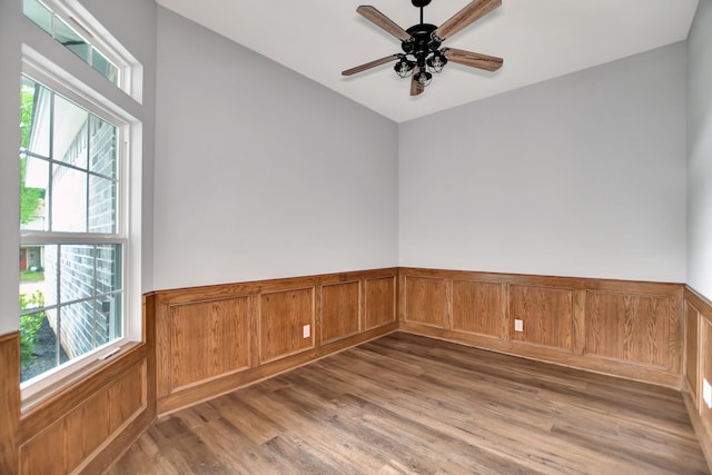 empty room featuring ceiling fan, plenty of natural light, and hardwood / wood-style floors