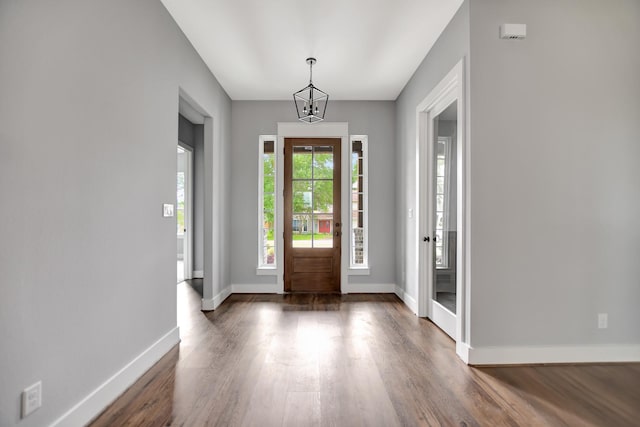 foyer featuring an inviting chandelier and dark wood-type flooring