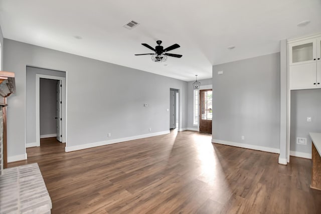 unfurnished living room with a fireplace, dark wood-type flooring, and ceiling fan