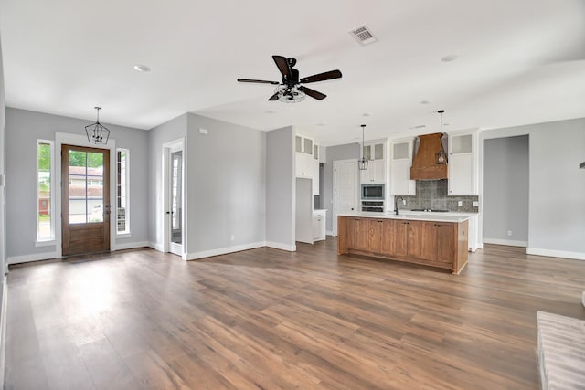 kitchen featuring a spacious island, premium range hood, stainless steel appliances, and white cabinets