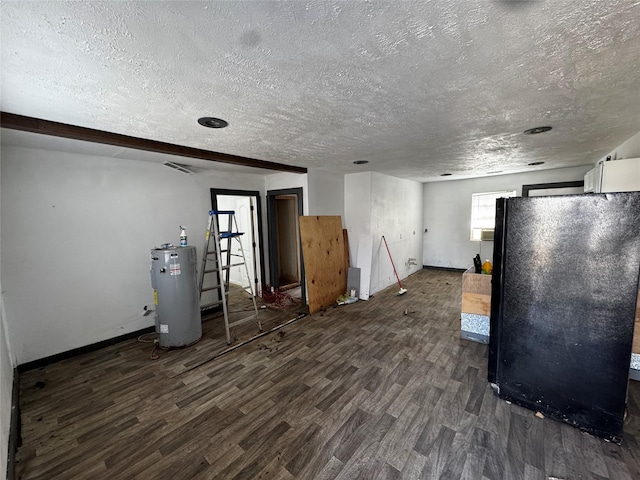 interior space featuring black refrigerator, dark wood-type flooring, electric water heater, and a textured ceiling