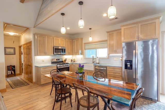 kitchen with light hardwood / wood-style floors, decorative light fixtures, stainless steel appliances, and decorative backsplash