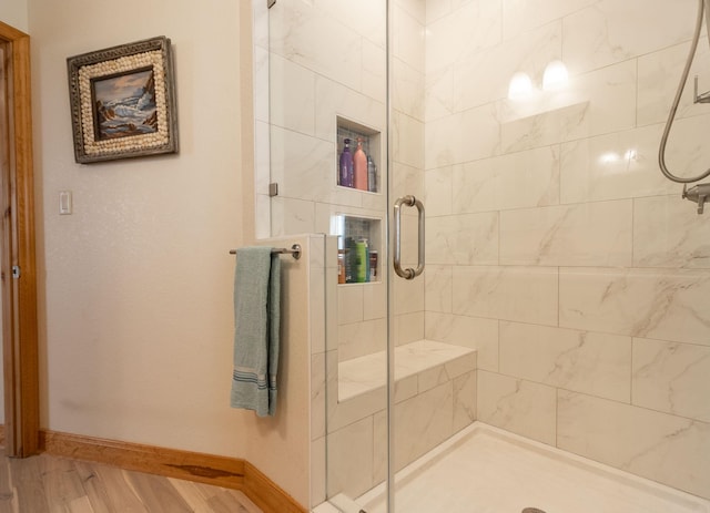 bathroom featuring wood-type flooring and a shower with door