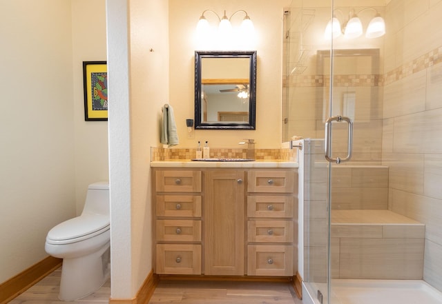 bathroom with vanity, hardwood / wood-style floors, a shower with shower door, and toilet