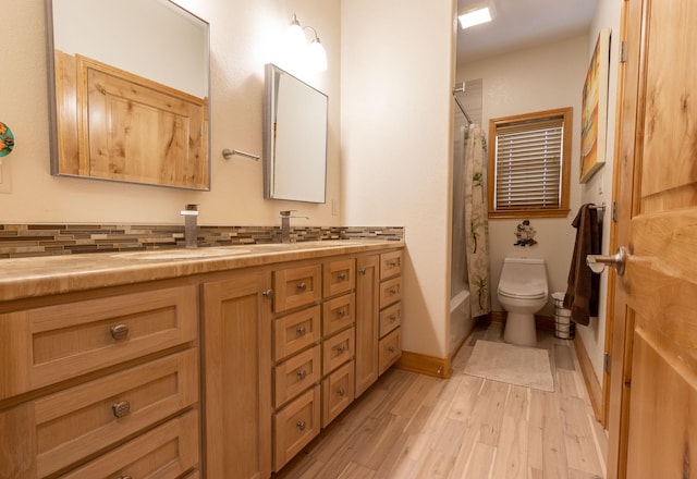 bathroom featuring toilet, vanity, a shower with shower curtain, hardwood / wood-style flooring, and decorative backsplash