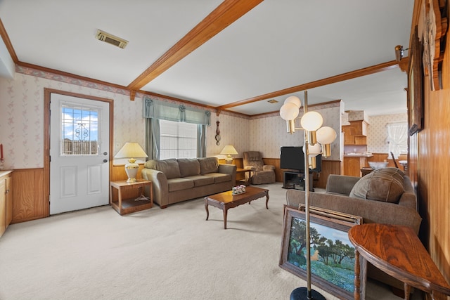 carpeted living room featuring beamed ceiling and crown molding