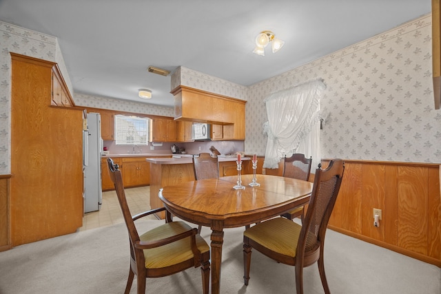 dining room with sink and light colored carpet