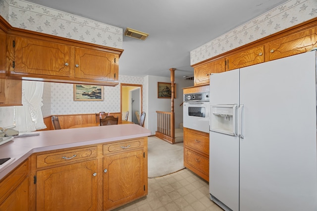 kitchen with white appliances and kitchen peninsula