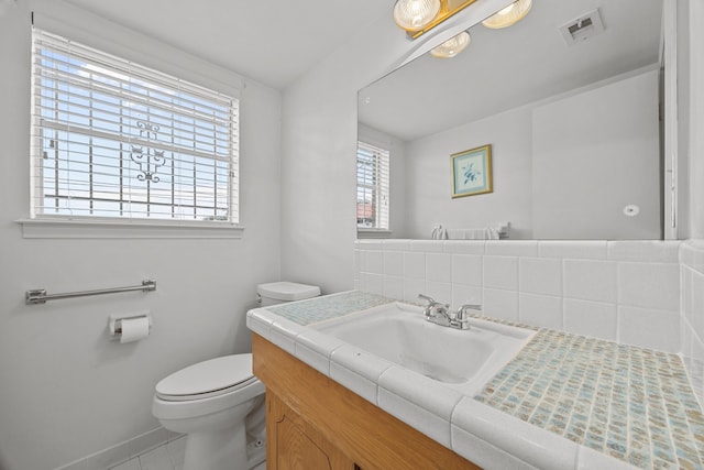 bathroom with vanity, backsplash, and toilet