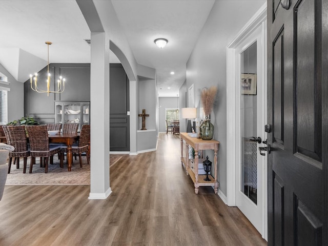 foyer entrance with hardwood / wood-style flooring and a chandelier