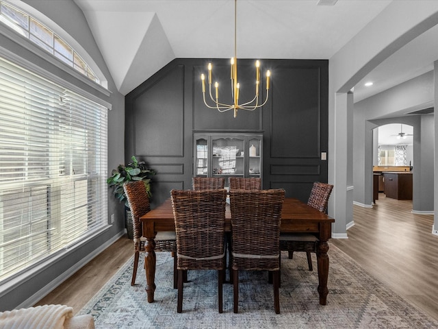 dining room with lofted ceiling, hardwood / wood-style floors, and a chandelier