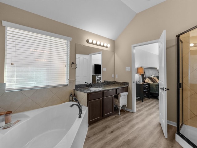 bathroom featuring vanity, shower with separate bathtub, vaulted ceiling, and hardwood / wood-style floors