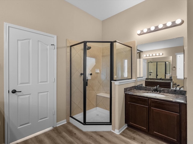 bathroom featuring vanity, hardwood / wood-style floors, and a shower with shower door