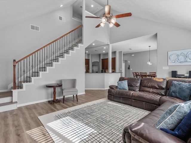 living room featuring high vaulted ceiling, light hardwood / wood-style floors, and ceiling fan