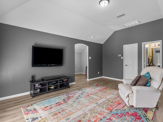 living room featuring vaulted ceiling and wood-type flooring