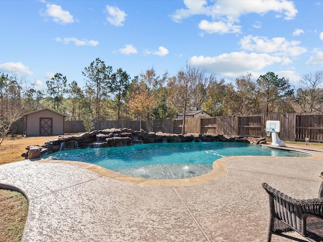 view of pool featuring pool water feature, a patio area, and a shed