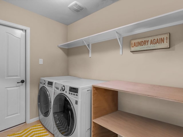 clothes washing area featuring tile patterned flooring and washer and dryer