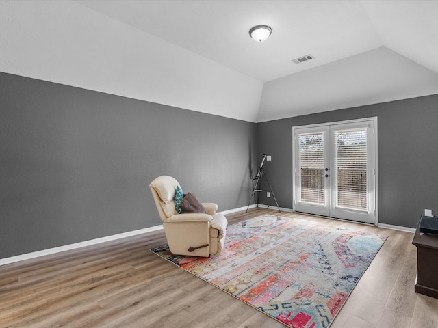 unfurnished room featuring lofted ceiling, hardwood / wood-style flooring, and french doors