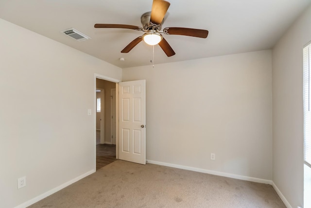 carpeted spare room featuring ceiling fan