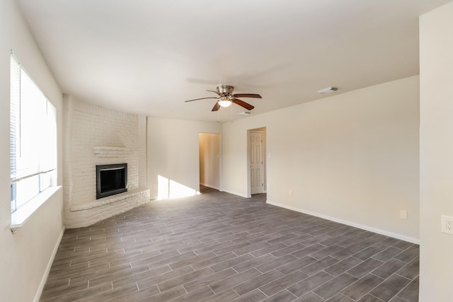 unfurnished living room with a brick fireplace and ceiling fan