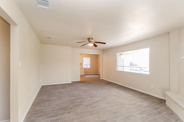 unfurnished room featuring ceiling fan, a healthy amount of sunlight, and light wood-type flooring