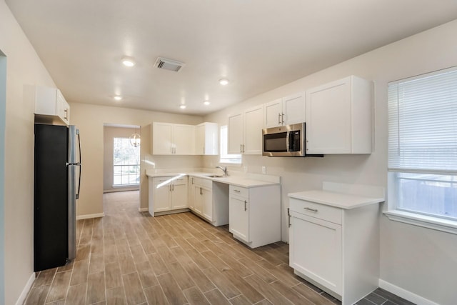 kitchen with white cabinetry, appliances with stainless steel finishes, and sink