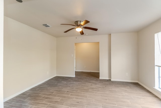 empty room with ceiling fan and light hardwood / wood-style floors