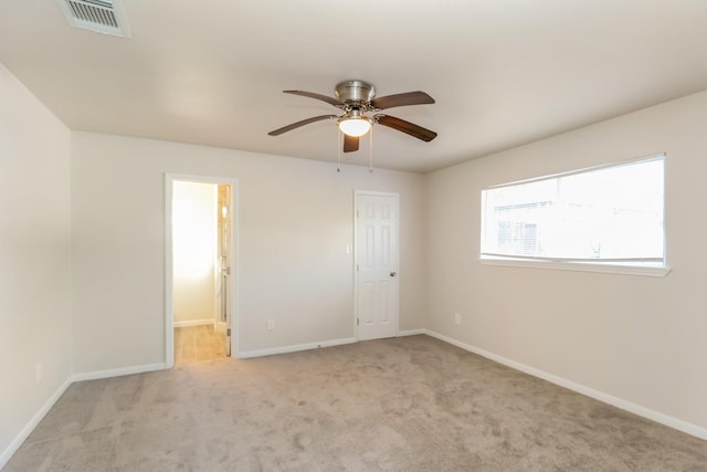 unfurnished bedroom with ceiling fan, light colored carpet, and ensuite bath