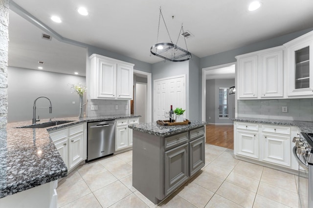 kitchen featuring sink, white cabinetry, a center island, light tile patterned floors, and stainless steel appliances