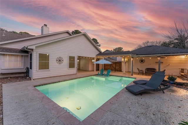 pool at dusk with a patio