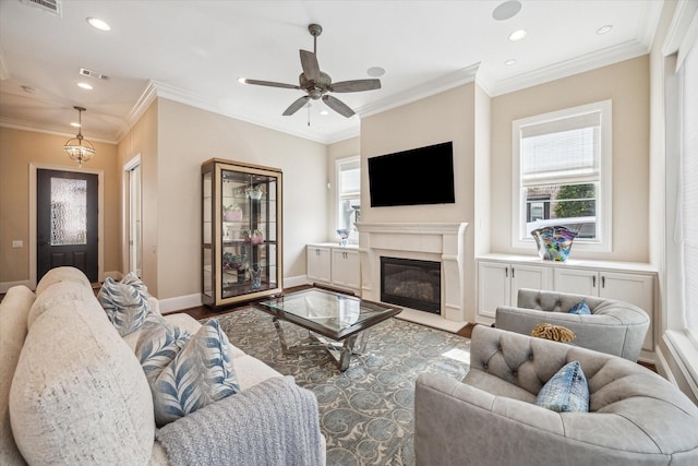 living room featuring hardwood / wood-style flooring, ornamental molding, ceiling fan, and a high end fireplace