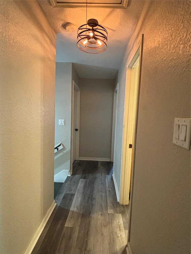 hall featuring a textured ceiling and dark hardwood / wood-style flooring