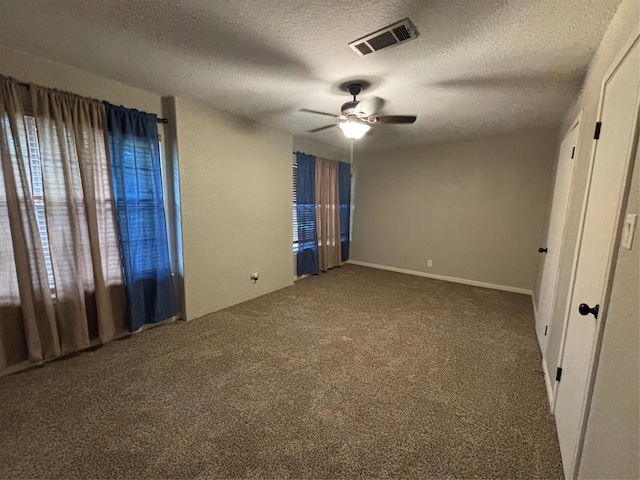 unfurnished bedroom featuring ceiling fan, a textured ceiling, and carpet