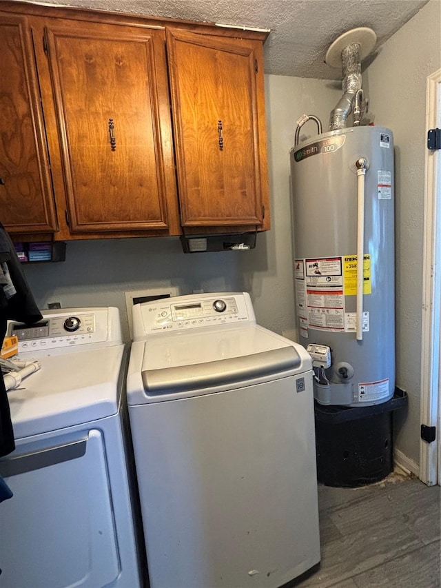 laundry room with washer and dryer, hardwood / wood-style floors, water heater, cabinets, and a textured ceiling