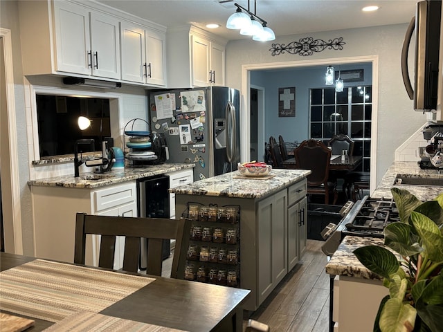 kitchen with white cabinetry, backsplash, stainless steel appliances, a center island, and wine cooler