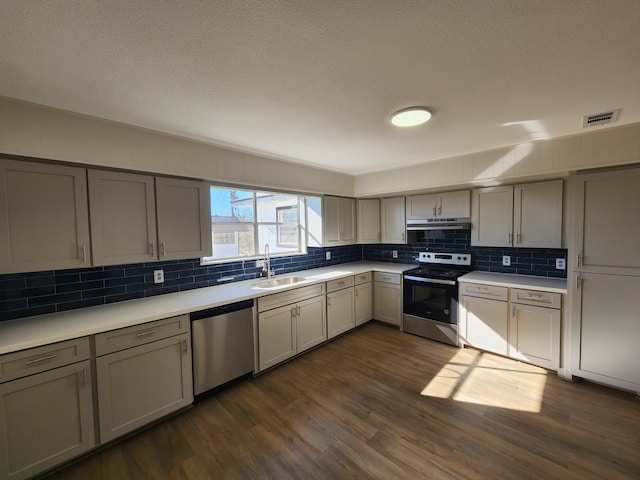 kitchen with gray cabinets, appliances with stainless steel finishes, sink, and dark hardwood / wood-style floors